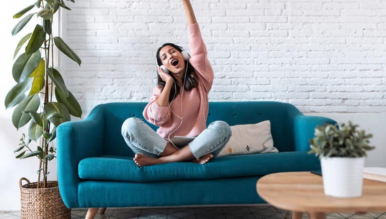 Motivated young woman listening to music with digital tablet whi
